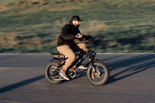 Adult rider on a fat-tire e-bike riding on a paved road