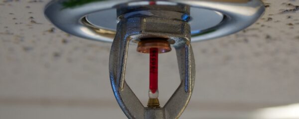 Close-up side view of a fire sprinkler head mounted on a ceiling
