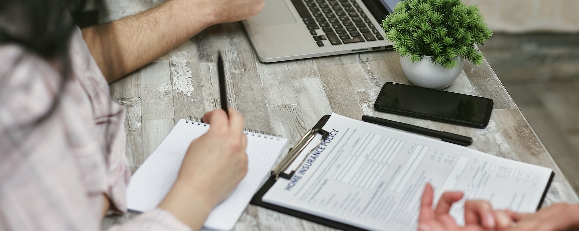 Couple reviewing auto insurance policy documents with an insurance agent